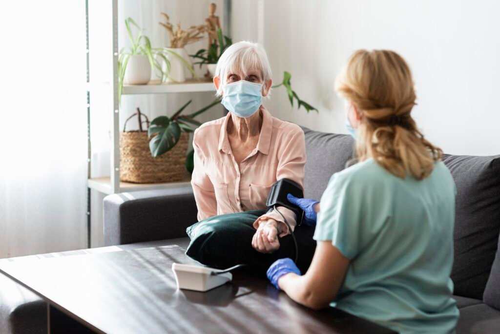 elder woman with medical mask having her blood pressure checked nursing home