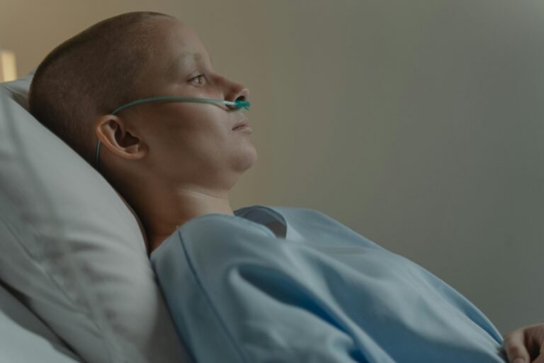A woman in a hospital bed with a nasal cannula, reflecting health challenges.